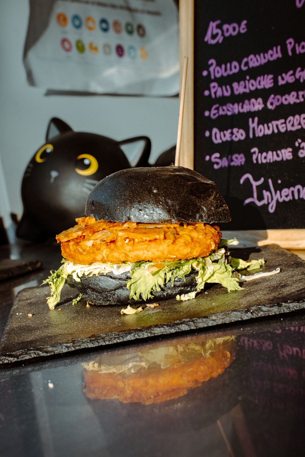-	Pan brioche 100% vegano<br/>  -	Hummus de remolacha <br/>  -	Medallón lila<br/>  -	Col lombarda marinada<br/>  -	Cebolla morada encurtida<br/>  -	“Queso” vegano fundido<br/>  -	Brotes morados (o rúcula baby)