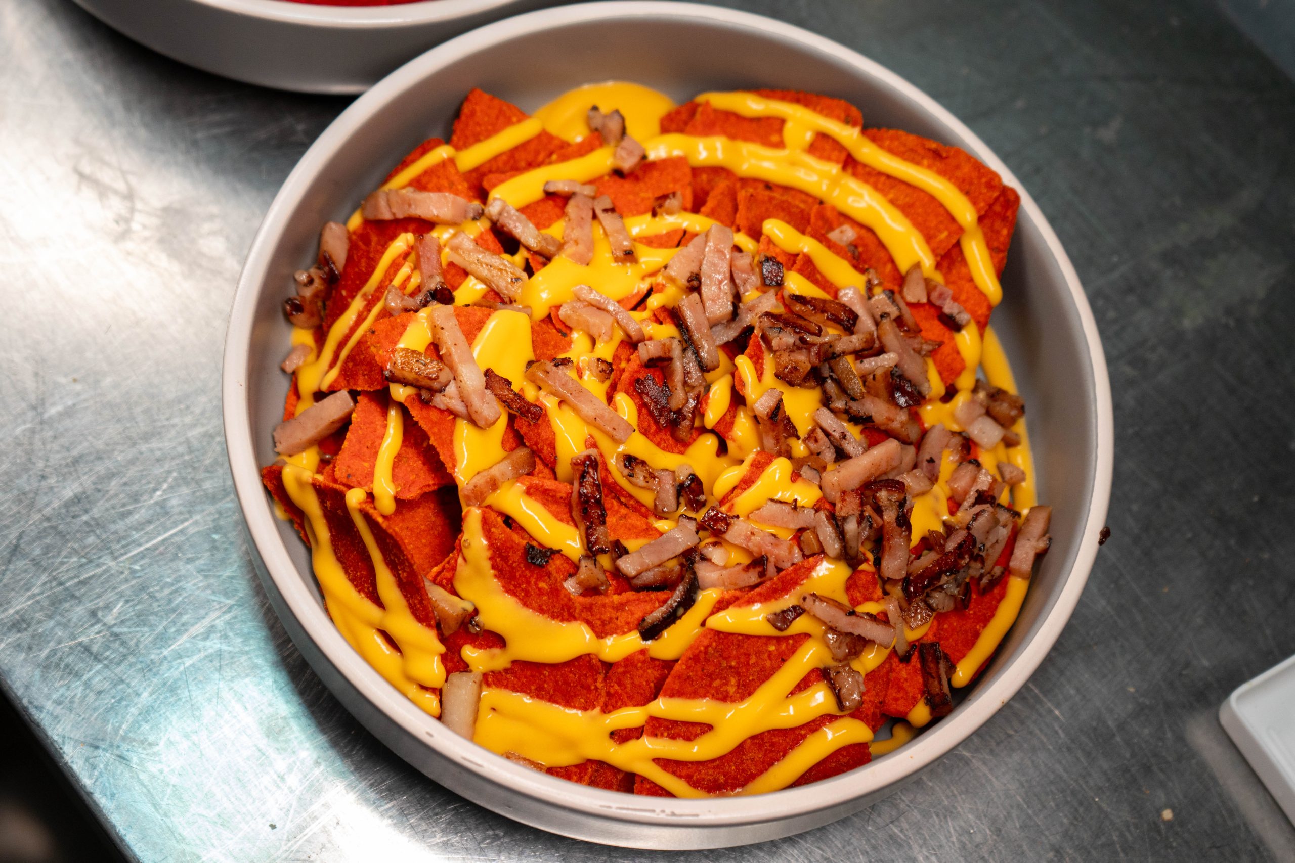 - Patatas fritas<br/> - Salsa Cheddar <br/> -	Bacon en tiras tostado <br/>-	Cebolla Crunch
